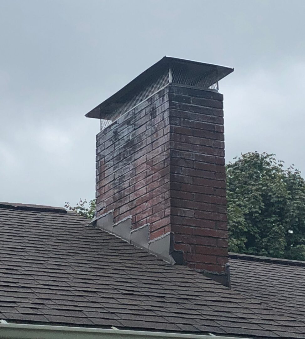 A brick chimney on the side of a roof.